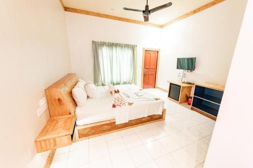 a bedroom with a bed and a tv in it at Veli Beach Inn in Mathiveri