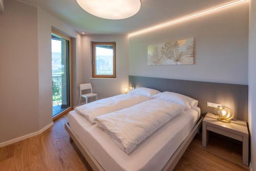 een slaapkamer met een groot bed en een groot raam bij Paulsner Feldhof in Appiano sulla Strada del Vino