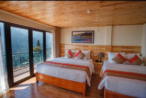 two beds in a room with a balcony at SaPa Retreat Condotel in Sa Pa