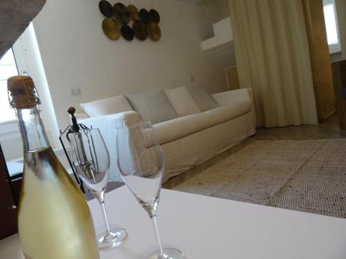 two wine glasses sitting on a table in a living room at LA DIMORA DELLE 3 ZIE in Matera
