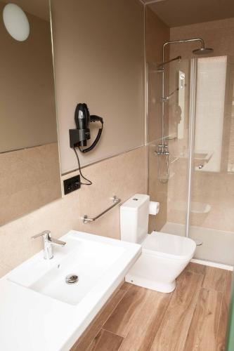 a bathroom with a sink and a toilet and a shower at Casa Rico de Medín in O Pino 
