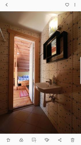 a bathroom with a sink and a door to a bedroom at Adeles sodyba in Sturmai