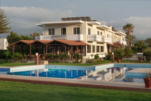 a large house with a swimming pool in front of it at Arion Hotel in Kolymvari