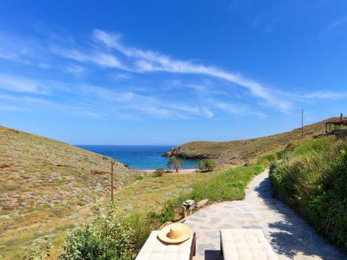 KorissiaにあるAgelos Beachfront Villaの海の横の小道に座るベンチ
