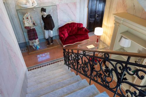 a stairway with a red chair and a display of clothes at Luxury Liberty House in Alghero