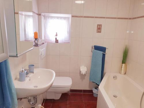 ein weißes Badezimmer mit einem Waschbecken, einem WC und einer Badewanne in der Unterkunft Ferienhaus am Osterberg in Quedlinburg