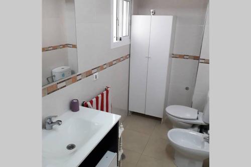 Baño blanco con lavabo y aseo en Campello Alicante Playa, en El Campello