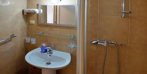 a bathroom with a sink and a shower with a mirror at SOBE MEDIĆ Međugorje in Međugorje