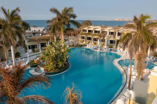 an overhead view of a large swimming pool with palm trees at Paradise Inn Beach Resort in Alexandria