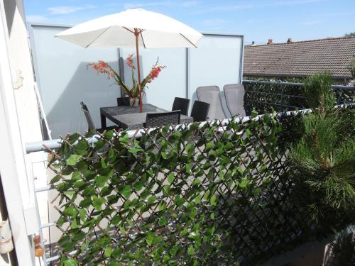 a patio with an umbrella and chairs on a balcony at Baie Sud Cayeux sur Mer ciel in Cayeux-sur-Mer