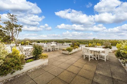 a patio with white tables and chairs and a view at Best Western The Webbington Hotel & Spa in Loxton