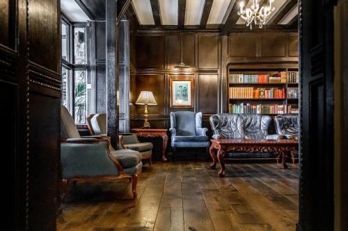 a living room with a couch and a book shelf at Best Western The Webbington Hotel & Spa in Loxton