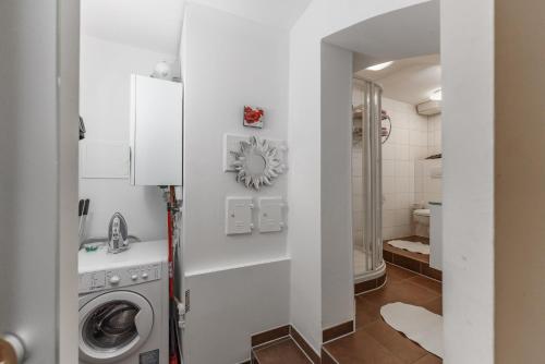 ein Badezimmer mit einer Waschmaschine und einem Waschbecken in der Unterkunft Easyapartments Altstadt 1 in Salzburg
