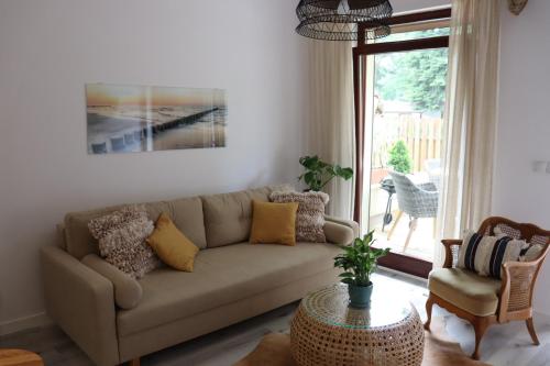 ein Wohnzimmer mit einem Sofa und einem Tisch in der Unterkunft Baltic Nature in Łukęcin