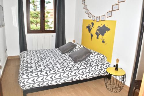 a bedroom with a bed with a black and white comforter at Verba Mundi Guest House in Olbia