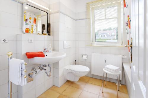 ein weißes Bad mit einem WC und einem Waschbecken in der Unterkunft Villa Kurpark Bad Saarow in Bad Saarow