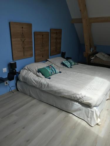 une chambre avec un grand lit dans une pièce bleue dans l'établissement l'auberge du mont de gez, à Arras-en-Lavedan