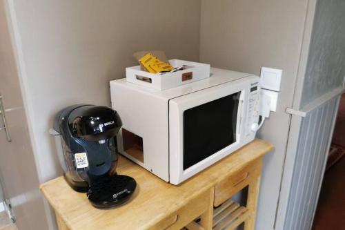 Un four micro-ondes est installé au-dessus d'une table en bois. dans l'établissement Le 3 de coeur avec terrasse, à Honfleur
