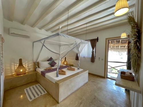 a bedroom with a bed with a canopy at Villa Huruma in Paje