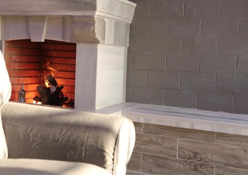 a living room with a fire place with a chair at Dar Gerasa chalets - شاليهات دار جراسا in Jerash