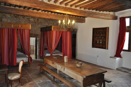 sala de estar con mesa y cortinas rojas en Domaine De Blancardy en Moulès-et-Baucels