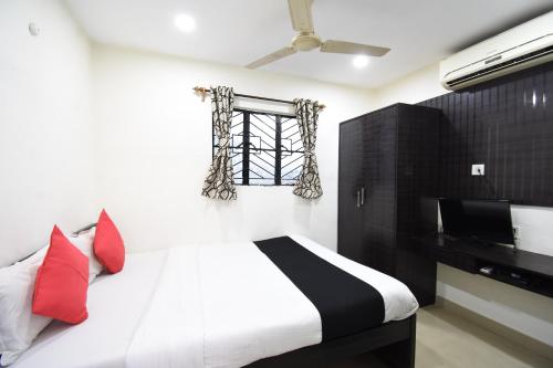 a bedroom with a bed with red pillows and a window at Hotel Nest International in Kolkata