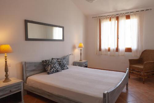 芡歐的住宿－DomoMea - Villetta dell'Agave，一间卧室配有一张床、一把椅子和镜子