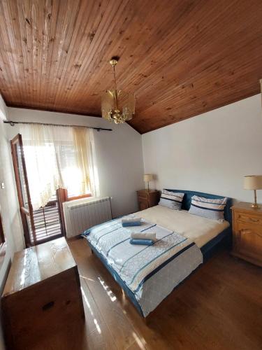 ツェティニェにあるHoliday Home Milanovicの木製の天井が特徴のベッドルーム1室(大型ベッド1台付)