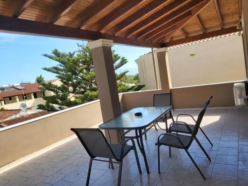 eine Terrasse mit Tisch und Stühlen auf einem Balkon in der Unterkunft Maria Apartments in Sidari