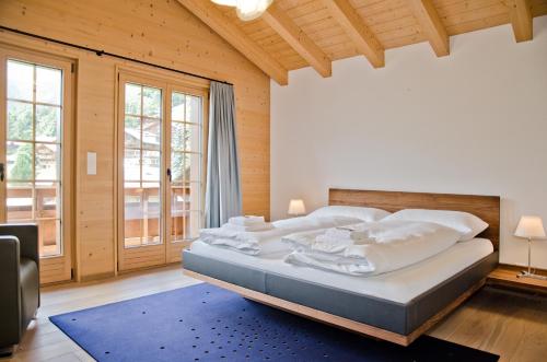 a bedroom with a large bed and a large window at Apartment Bränderli - GRIWA RENT AG in Grindelwald