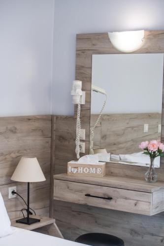 a bedroom with a bed with a mirror and a lamp at Aggelos Apartments & Deluxe Studios in Nydri