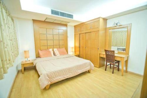 a bedroom with a bed and a desk in it at JOLLY GUESTHOUSE & RESTAURANT in Pattaya Central