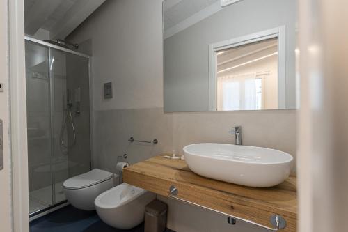 a bathroom with a sink and a toilet and a mirror at La Scala Suite in Realmonte