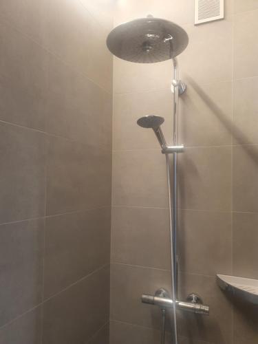 a shower with a shower head in a bathroom at Appartement met 2 slaapkamers op zeedijk Middelkerke in Middelkerke