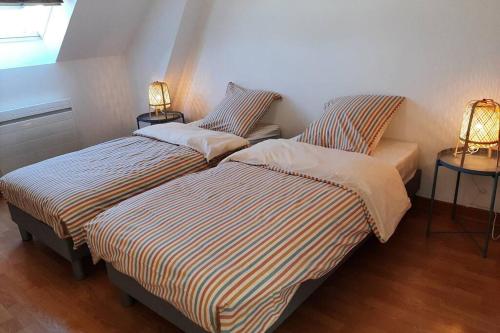 two beds sitting next to each other in a room at LA MAISON BLEUE in Saint-Sauveur-des-Landes