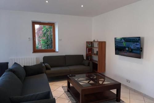 un salon avec un canapé et une table basse dans l'établissement LA MAISON BLEUE, à Saint-Sauveur-des-Landes