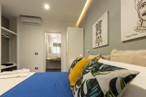 a bedroom with a bed with blue and yellow pillows at La Scala Suite in Realmonte