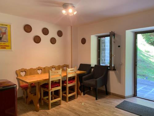a dining room with a wooden table and chairs at alla curva del Pagliai in Abetone