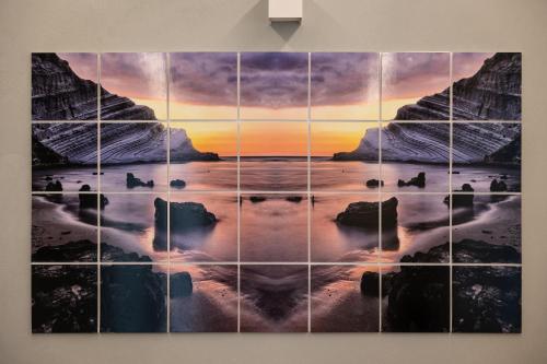 a painting of a sunset over the ocean at La Scala Suite in Realmonte