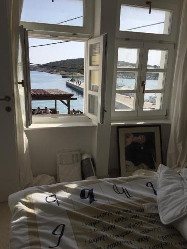 a bedroom with windows and a bed with a view of the water at VILLA IL BLU direkt am Meer in Martinšćica