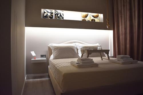 a bedroom with a bed with towels on it at Alto Suite (Cielo suites) in Kavala