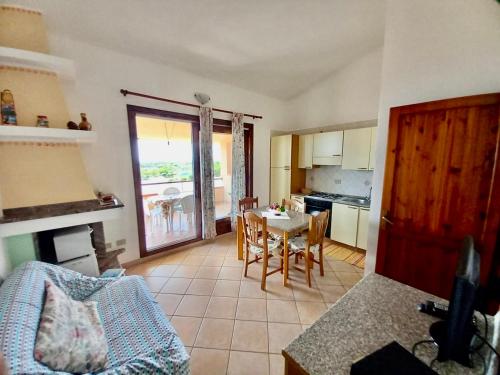 una cucina e un soggiorno con tavolo e sedie di Casa Vacanza Porto Corallo a Villaputzu