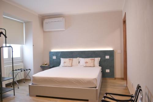 1 Schlafzimmer mit einem weißen Bett und einem blauen Kopfteil in der Unterkunft Garda Lake Maison d'Isabella in Lonato