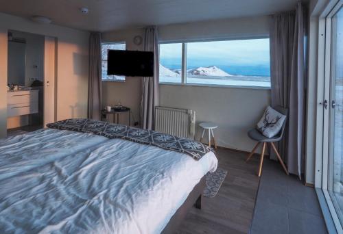 a bedroom with a large bed and a large window at Farmhouse Lodge in Vík