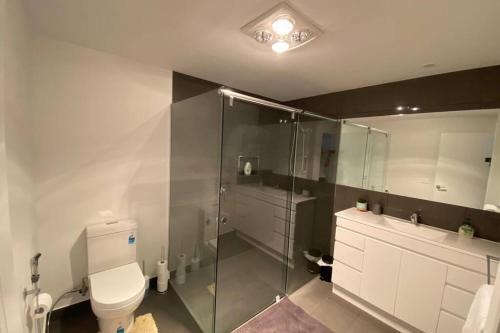 een badkamer met een toilet en een glazen douche bij Spacious, Contemporary and Self-Contained with Beautiful Views in Kingston