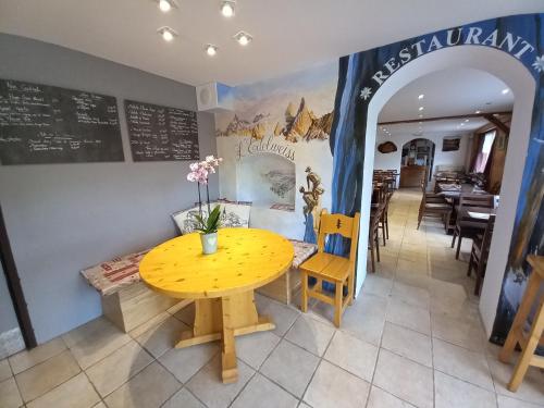 a dining room with a yellow table and chairs at Hôtel l'Edelweiss in Châtel