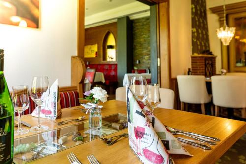 a table with wine glasses and a bottle of wine at Akzent Waldhotel Rheingau in Geisenheim