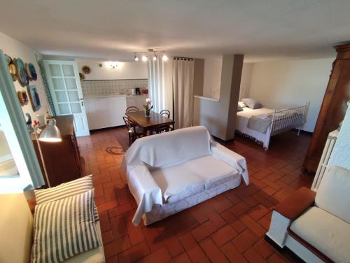 ein Wohnzimmer mit einem Sofa und einem Bett in der Unterkunft Independent apartment with a fabulous patio - Casa Penny in Cisano sul Neva