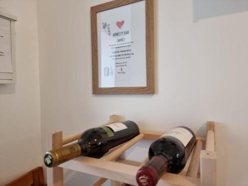 two bottles of wine on a shelf with a picture at Dream Days Guesthouse in Faro