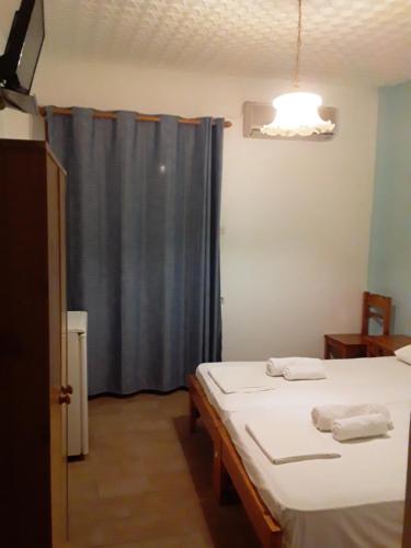 a room with two beds and a blue curtain at Ethra in Patitiri